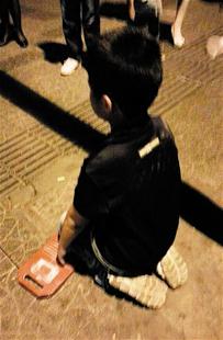 儿子玩了一天没做作业 父母罚孩子当街跪搓衣板